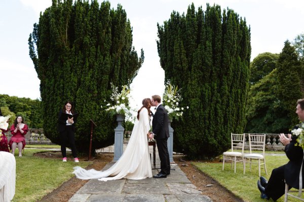 Bride and groom at alter kiss