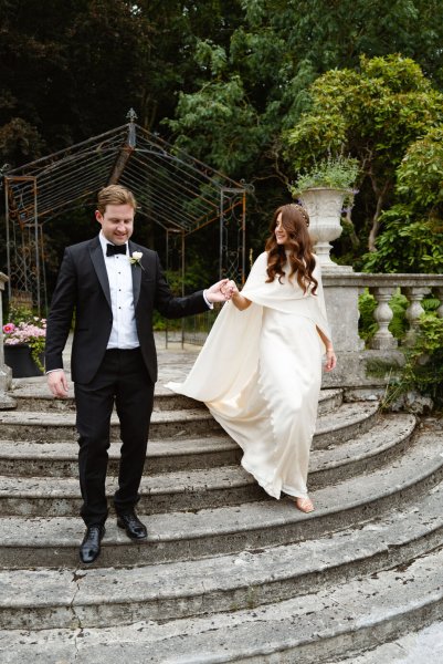 Bride and groom holding hands walking down steps