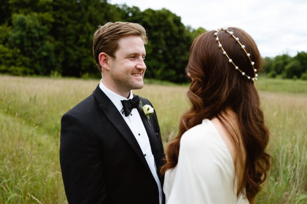 Groom looks at bride bridal hair wavy detail