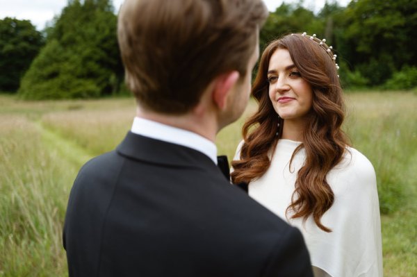 Bride and groom look at each other wavy hair