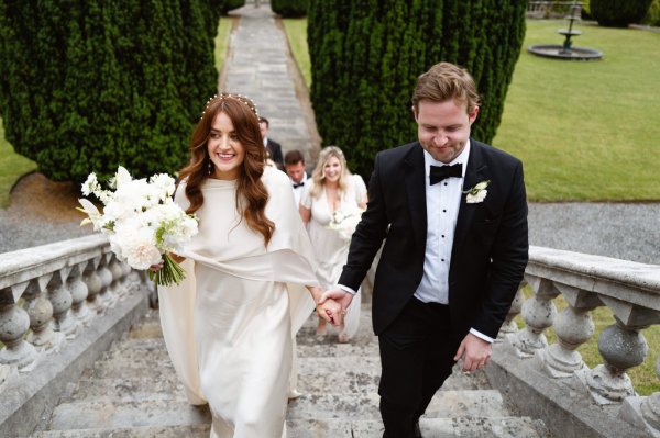 Bride and groom walk up steps bridesmaids follow