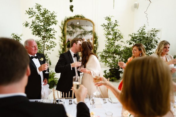 Bride and groom kiss in front of guests