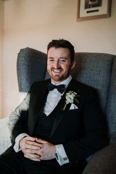 Happy groom sitting down