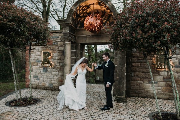 Exterior bride and groom in courtyard swinging dancing