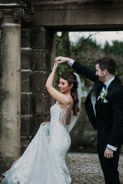 Exterior bride and groom in courtyard swinging dancing