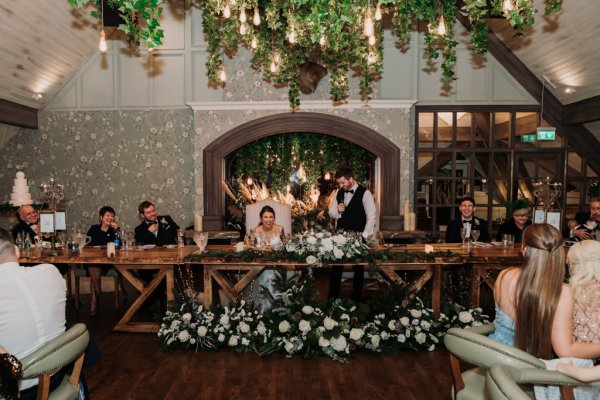 Bride and groom laugh during ceremony at table speech speeches