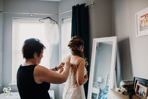 Mother bridesmaids help bride get ready mirror