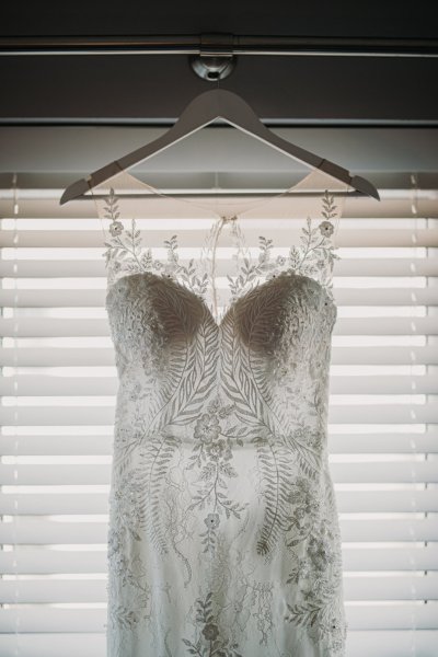 White laced wedding dress hanging up