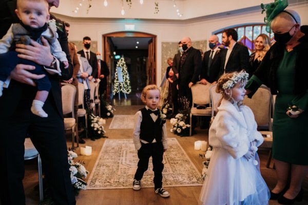 Little flower boy holds flowers