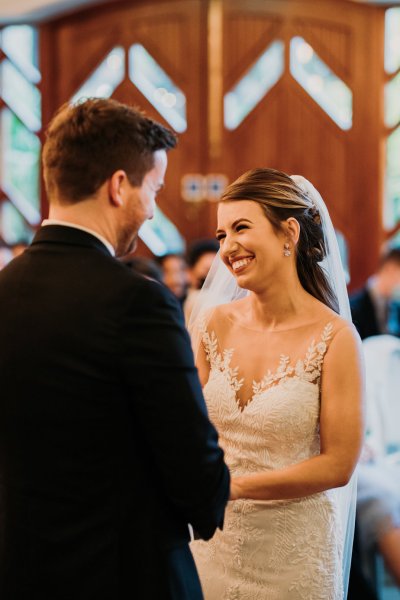 Bride and groom exchanging wedding bands/rings smiling