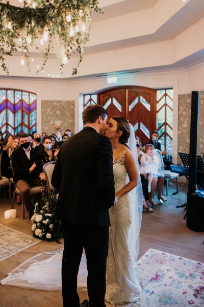 Bride and groom kiss kissing in front of guests