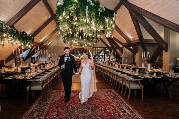 Bride and groom walk inside dining room