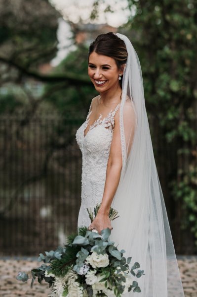 Exterior shot of bride long train and veil flowers forest detail