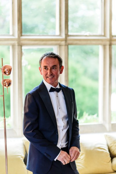 Groom on his own beside window