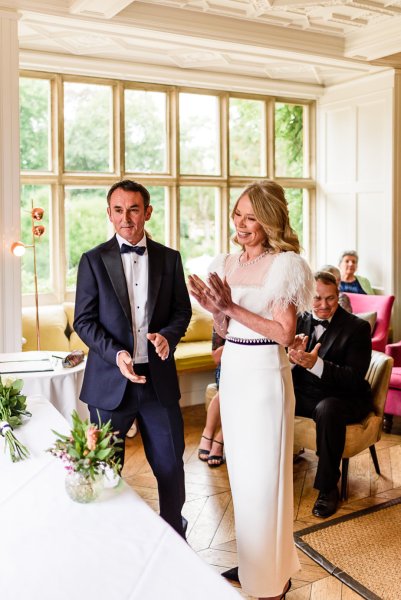 Bride and groom at alter with guests clapping