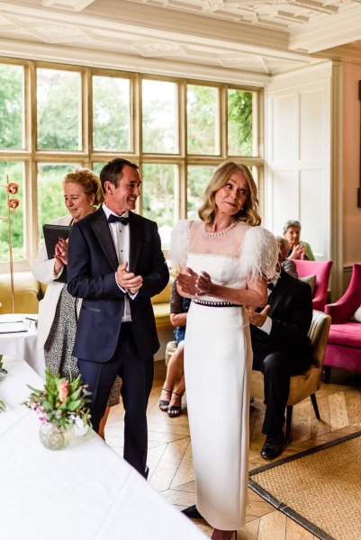 Bride and groom at alter with guests clapping