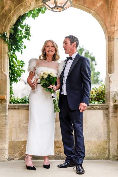 Bride holding bouquet of flowers with groom exterior shot