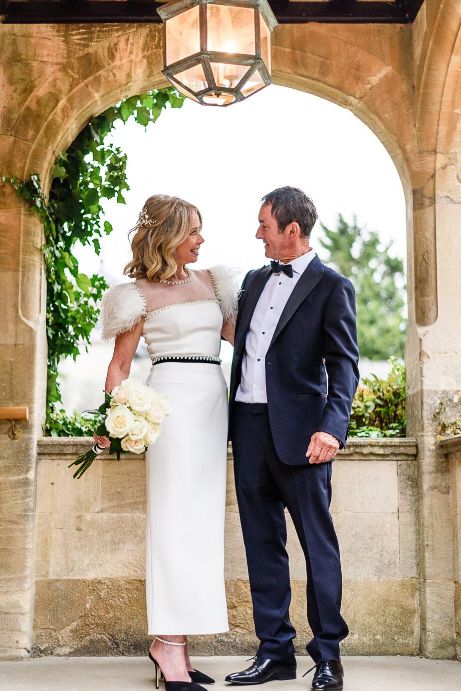 Bride holding bouquet of flowers with groom exterior shot