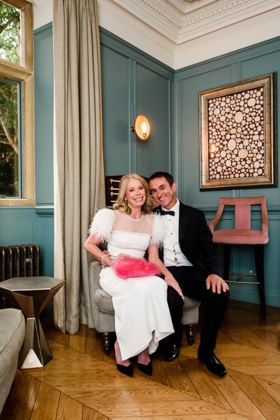 Bride sitting beside groom with red fluffy purse on lap