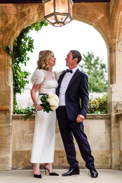 Bride holding bouquet of flowers with groom exterior shot