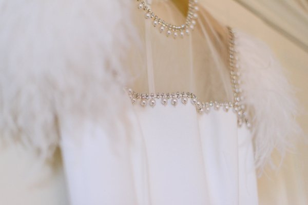 Up close feather detail brides bridal gown/dress and pearls