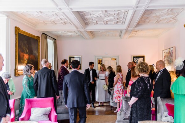 Bride and groom exit ceremonial room with guests