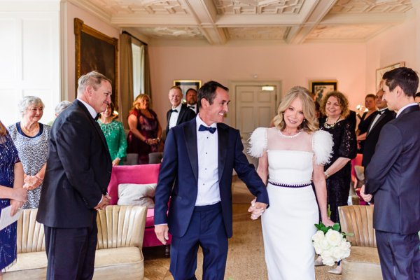 Bride and groom exit ceremonial room with guests