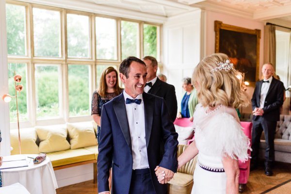 Bride and groom holding hands in front of guests