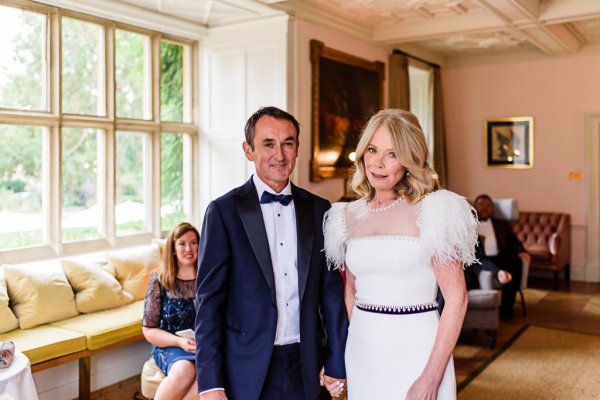 Bride and groom in front of guests at alter smiling