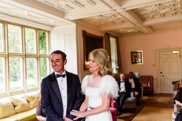 Bride and groom in front of guests at alter