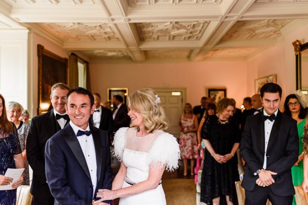 Bride and groom in front of guests at alter