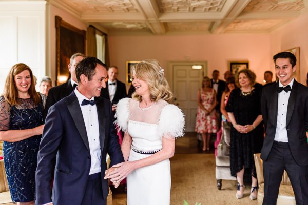 Bride and groom laughing and smiling in front of guests