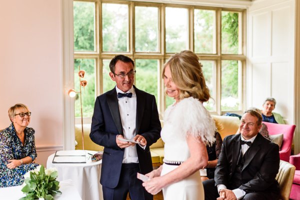 Bride and groom laughing and smiling reading vows