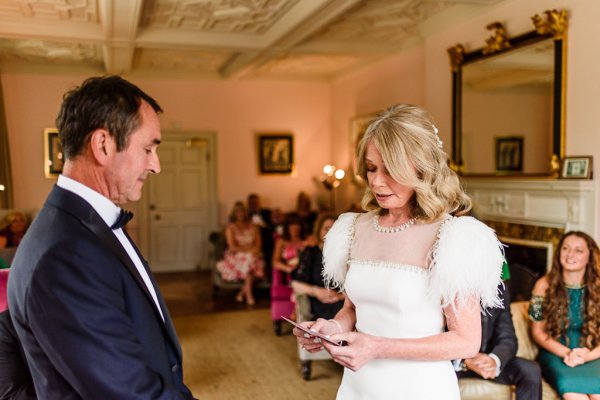 Bride and groom laughing and smiling reading vows