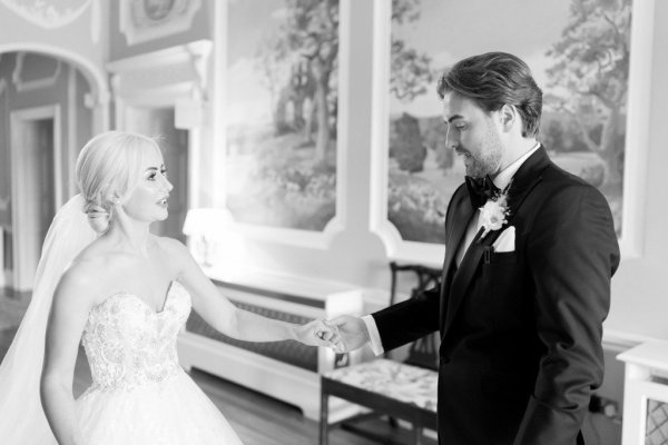 Bride and groom hold hands black and white