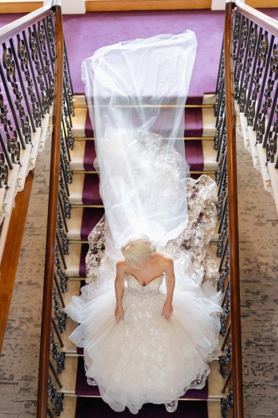 Shot of bride and veil/train from above staircase