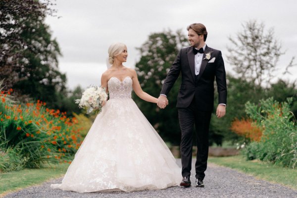 Bride and groom holding hands exterior shot