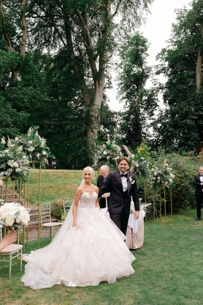 Bride and groom exit ceremony with guests