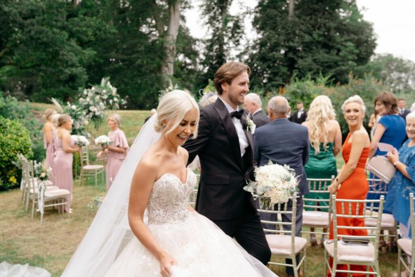 Bride and groom exit ceremony with guests