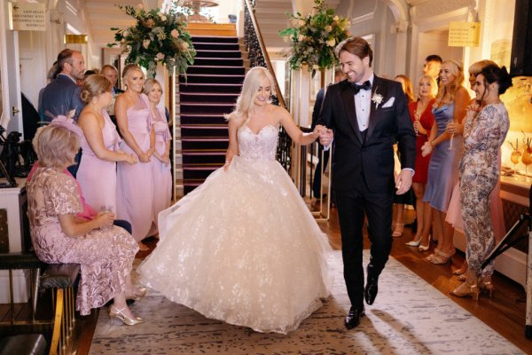 Large dress lace holding hands bride and groom