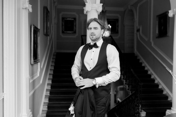 Black and white groom suit and tie stairs in background