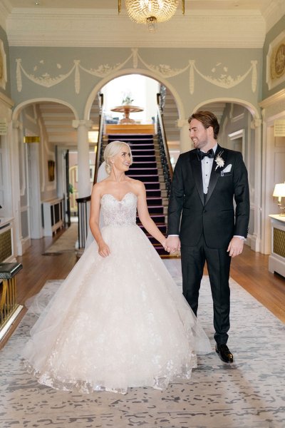 Bride and groom hold hands interior shot