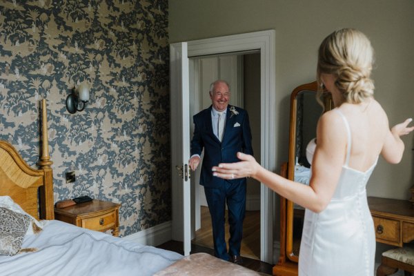 Father of the bride walks in to see bride