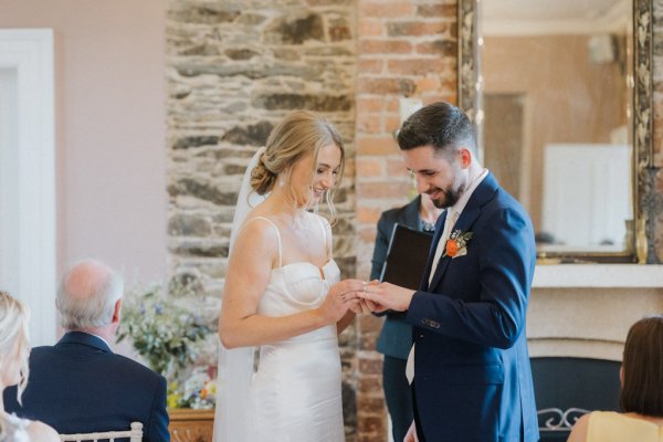 Bride and groom put wedding rings/bands on