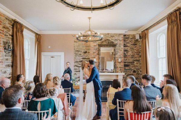 Bride and groom kiss at alter