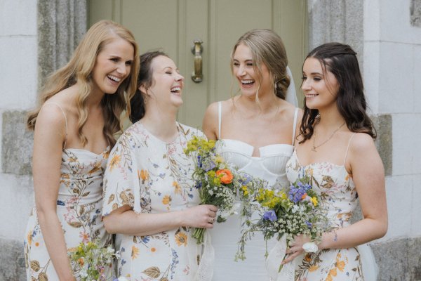 Bride and bridesmaids holding bouquet of flowers