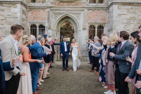 Bride and groom exterior church with guests clapping