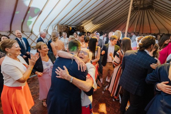 Guest/mother hugs groom