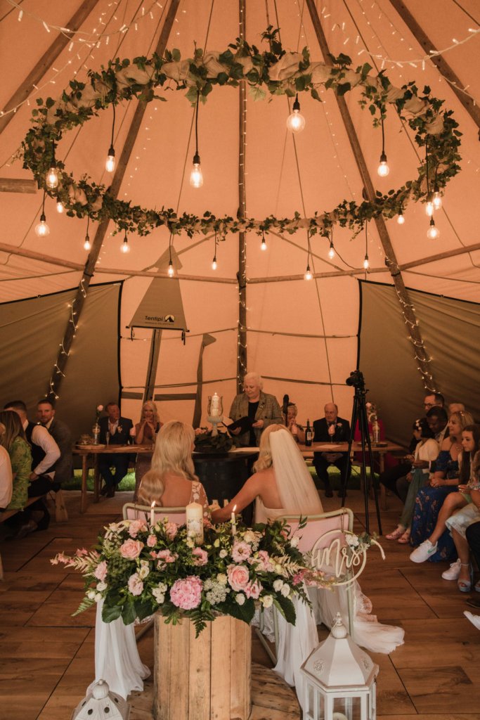 Bride and bride officiant at alter under marquee tent