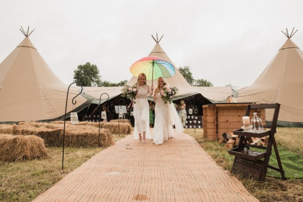 Rainbow umbrella bride and bride walk down the aisle